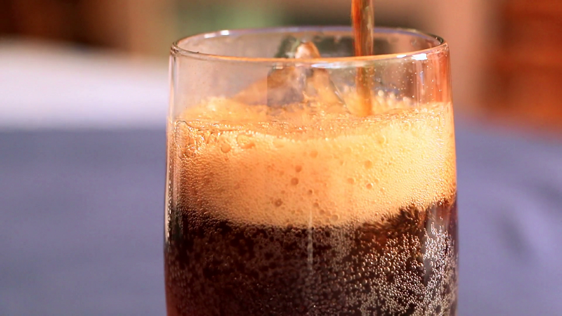 Soft drink is poured into a glass
