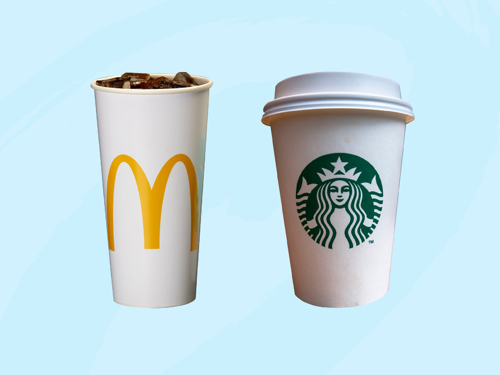 A McDonald's cup and Starbucks cup sit next to each other