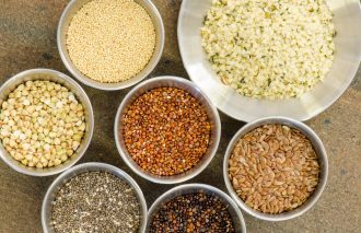 Ancient grains and healthy organic edible seeds in round stainless steel containers. These are considered superfoods.