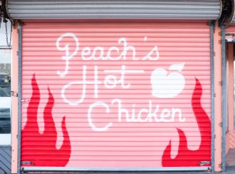 Peach's Hot Chicken text on pink garage door