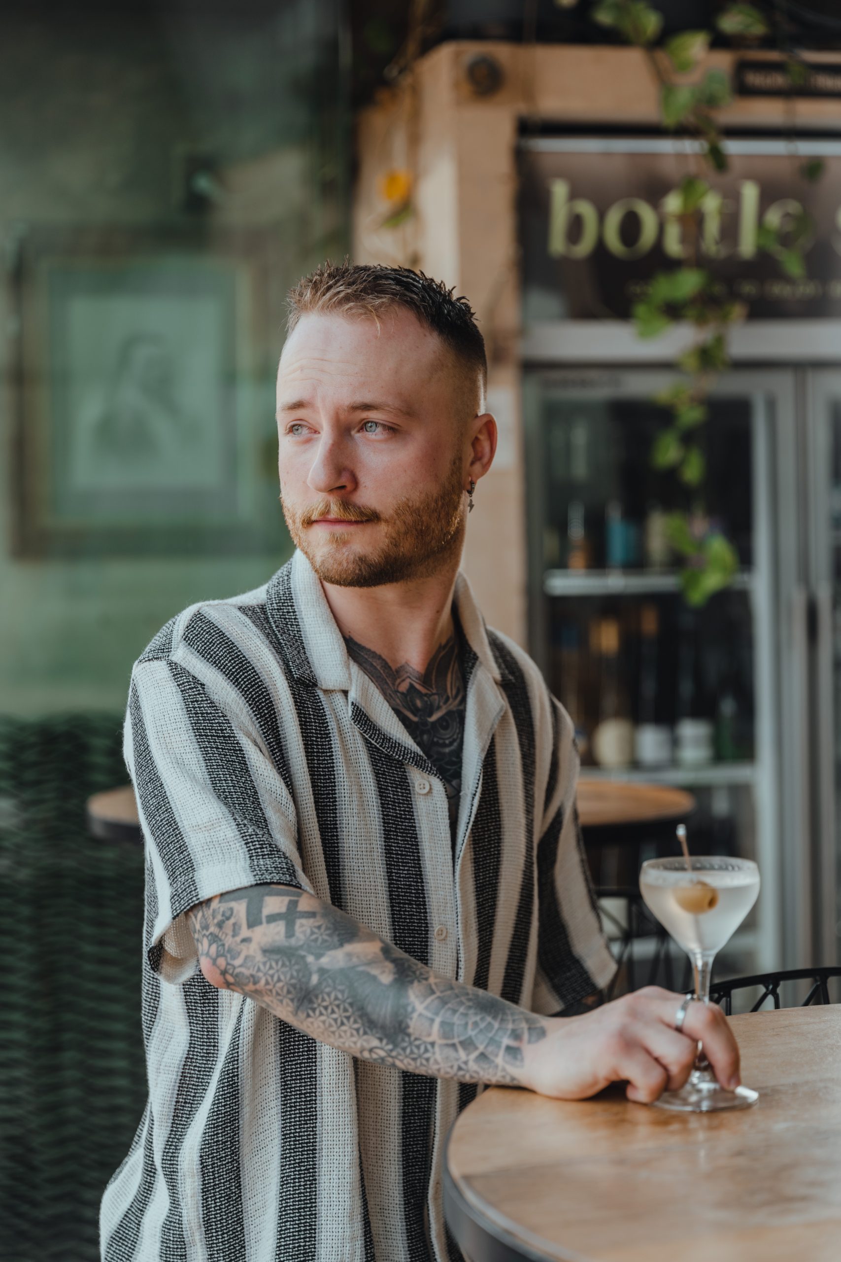 Man standing by table and cocktail at bar