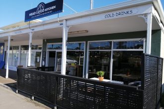 Restaurant outside view, white panelling and black fenced decking