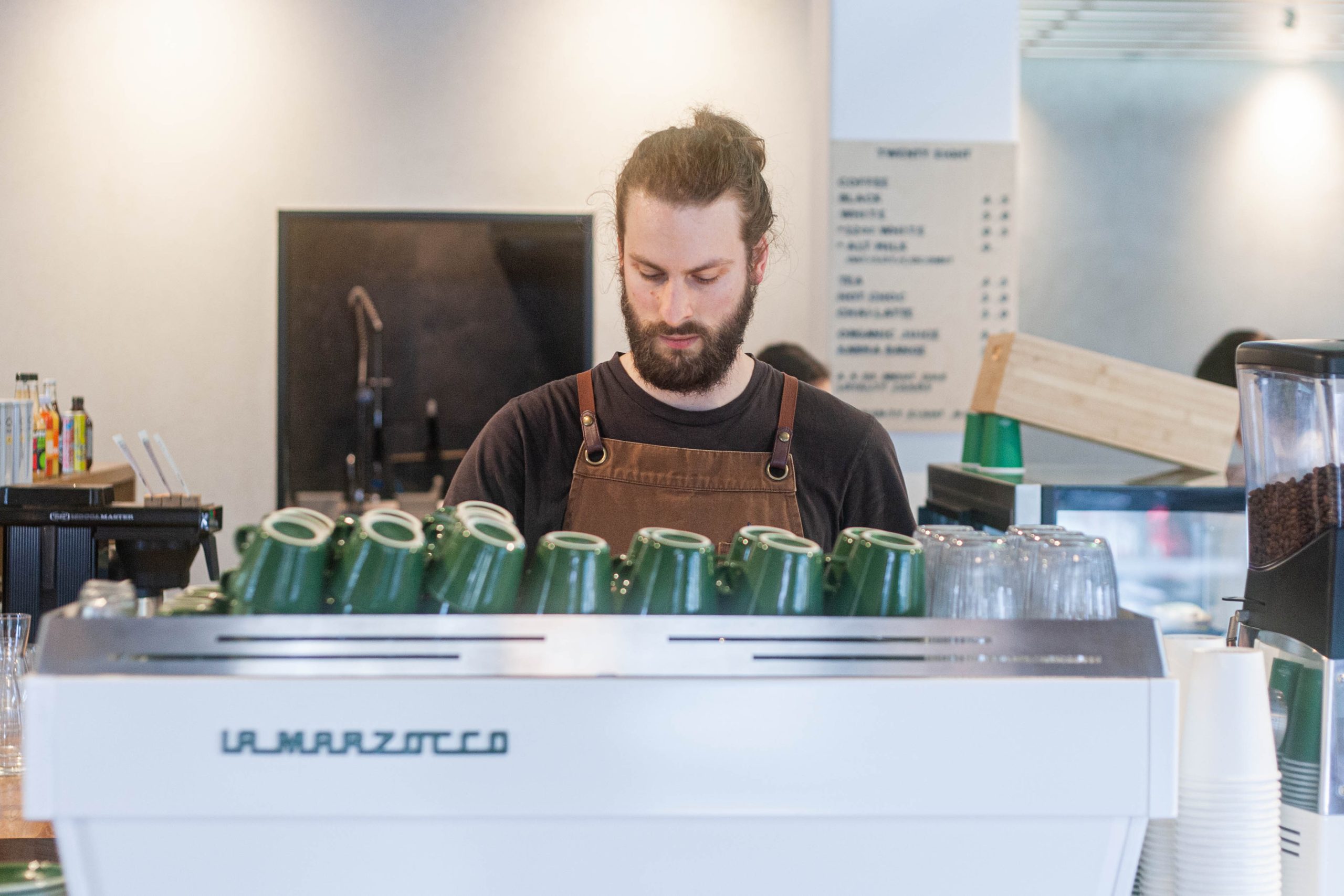barista looking down at coffee machine
